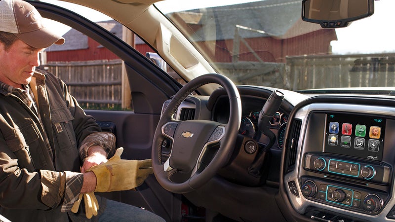 Man in driver's seat showcasing steering wheel and smart display."